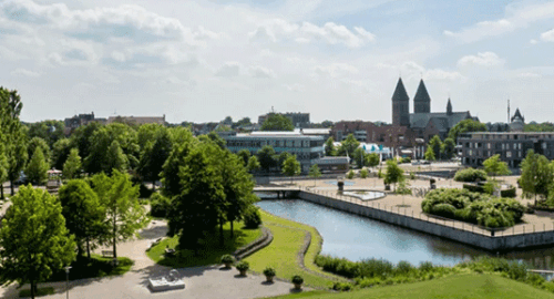 Panoramablick auf eine charmante Stadt mit Wasserkanal, Parkanlagen und Kirchtürmen