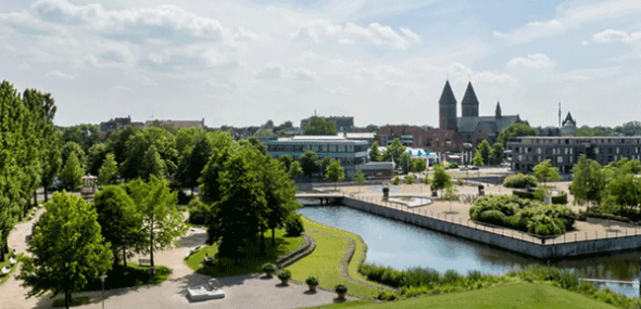 Panoramablick auf eine charmante Stadt mit Wasserkanal, Parkanlagen und Kirchtürmen