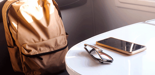 Forgotten backpack, sunglasses and smartphone on a table inside a train