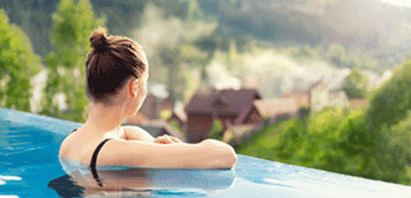 Entspannung in einem Infinity-Pool mit Blick auf grüne Natur und Hügellandschaft
