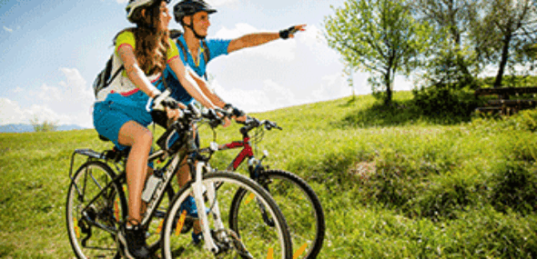 Radfahrer mit Helmen machen bei einer Fahrradtour Rast in der Natur
