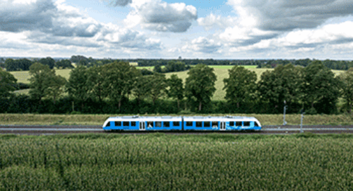 Blue regional train traveling through the idyllic countryside landscape of Grafschaft Bentheim